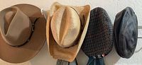 all four hats hanging on wall