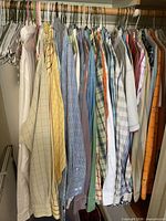 Full closet view of hanging shirts showing variety of colours, patterns and sleeve lengths