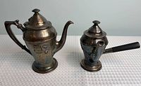 Both silver-plated teapots full view