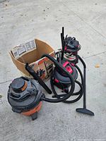 Group of three Shop-Vac vacuums with hoses, wands, nozzle and box
