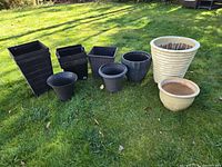 Eight assorted planters arranged on lawn