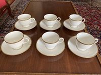 Six cups each on matching saucer arranged on table