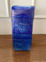 Front view of rectangular cobalt blue iridescent glass vase with twisted rim