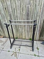 Front view of garment rack showing two chrome bars and bottom wire shelf
