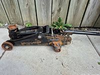 Left side profile of Husky trolley jack showing wheels, lifting arm, and rust