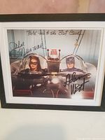 Front view of framed Batman and Catwoman reprinted photo with printed signatures