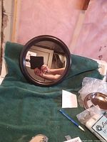 Front view of round wall mirror on green fabric