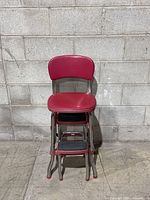 Front view showing red seat, backrest and folded steps