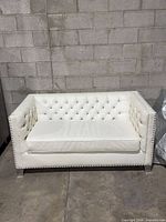 Front view of white tufted loveseat