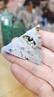 Front view of triangular polished ocean jasper showing druzy pocket with green bubble formations
