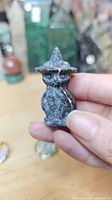 Front view of carved stone owl figurine with witch hat