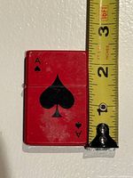 Front view of lighter beside measuring tape showing 2.25 in height