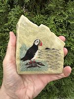 Front view showing full puffin illustration and stone shape in hand for scale