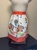 front view of apron on mannequin showing waistband, main pattern and hem band