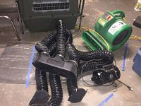 Photo showing black triple blower attachment hose with three individual nozzles and Metro Air Force Blaster fan blower in green and yellow.