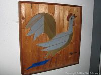 Wooden rooster wall art, natural wood background with stylized grey and olive rooster, signed artwork, approximately 24x18 inches.
