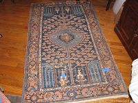 Blue and tan leaf motif area rug approximately 5'10" x 3'4"