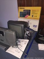 Toshiba TiVo Central SDH400 box, Broksonic 13 inch TV, and other electronics on table
