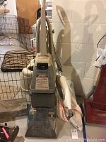Hoover Steam Vac Deluxe upright vacuum in worn condition with clear water tank, hose, and power cord visible in basement setting.