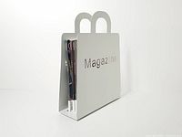 Three-quarter view showing white metal magazine holder with magazines inside, cutout text visible