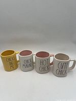 Front view of all four mugs displaying text and interior colors