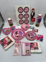 overview of all Barbie party supplies, sticker sheet, standee, candy box, cards and accessories