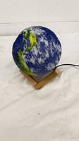 Earth globe night light on wooden stand, side view