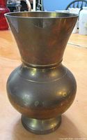 Front view of brass spittoon/vase showing flared rim and bulbous body