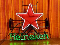 Full view of illuminated Heineken neon sign showing red star and green lettering