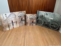 Three canvas prints standing on floor showing relative sizes and themes