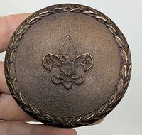 Front of bronze paperweight showing BSA emblem and laurel wreath border
