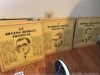 Three LP albums with illustrated portrait covers of Irving Berlin, Harold Arlen, and George Gershwin on a shelf.