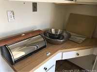 Bread box, mixing bowls, and cutting boards on countertop