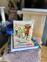 Stack of children’s books topped by One Love board book