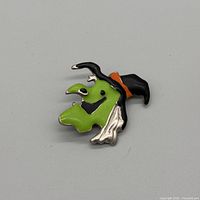 front view of enamel witch brooch showing colours and design