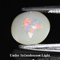 Front view of oval cabochon opal under incandescent light showing play-of-color