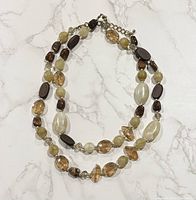 Full view of necklace on flat surface showing bead types and clasp