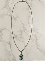 Full view of necklace laid flat showing chain and pendant