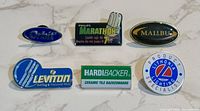 Front view showing all six enamel lapel pins with brand logos
