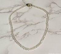 Full view of the necklace laid flat showing complete strand and clasp