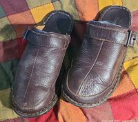 Top view of both brown leather mules