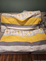 Both quilted shams laid flat showing striped floral fronts