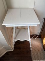 Top view of white painted parlour table showing square surface and turned legs