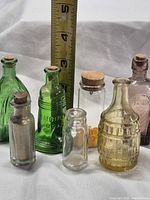 Group shot of all seven miniature bottles with ruler for scale