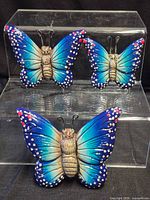 Front view of three ceramic butterfly wall decor pieces