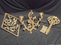 All four gold-tone decorative pieces laid out