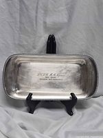Full view of silver-plated rectangular tray on stand showing engraving and rope rim