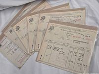 Group of invoices in plastic sleeves fanned out showing logos and dates