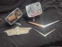 Full lot showing two mirrors, bowtie emblem, two V-shaped trim pieces