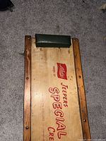 Full view of wooden mechanic creeper showing logo, headrest and casters